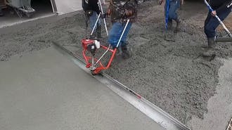 A concrete contractor operating concrete machine.
