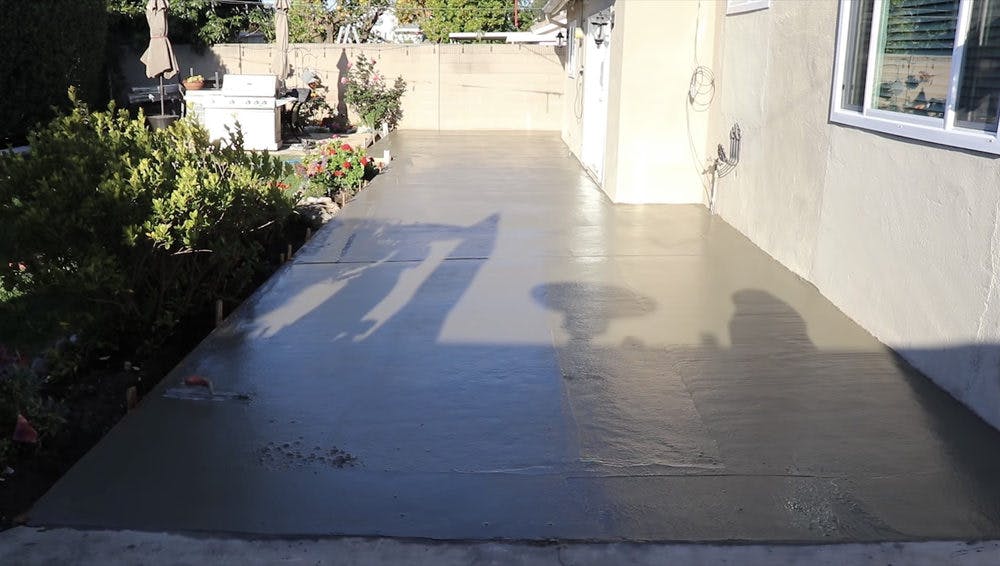 Wet and unfinished concrete patio surface.